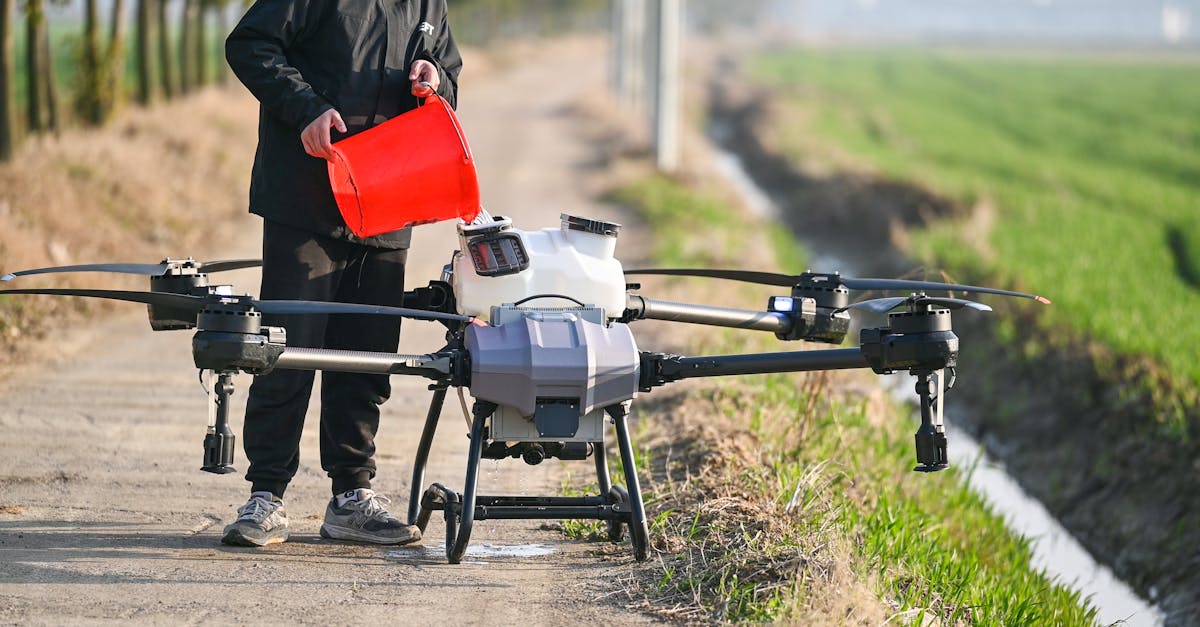 Person using a drone for agricultural purposes on a countryside pathway in Hefei, China.